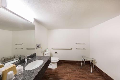 a bathroom with a toilet and a sink and a mirror at Motel 6-Knoxville, TN in Knoxville