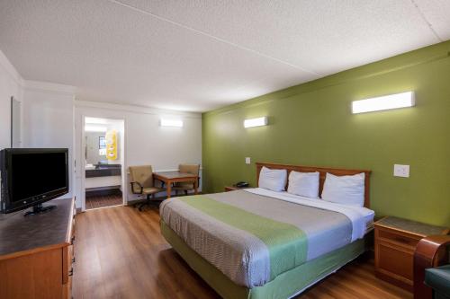 a hotel room with a bed and a flat screen tv at Motel 6-Knoxville, TN in Knoxville
