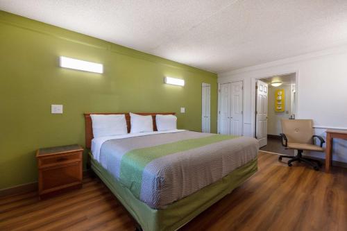 a bedroom with a large bed with a green wall at Motel 6-Knoxville, TN in Knoxville