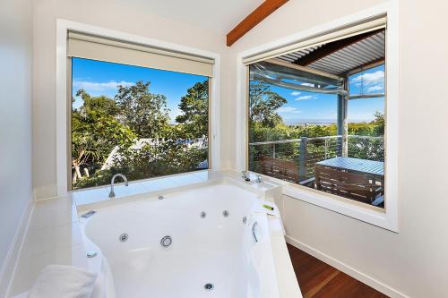 a bath tub in a bathroom with a large window at Maleny Terrace Cottages in Maleny