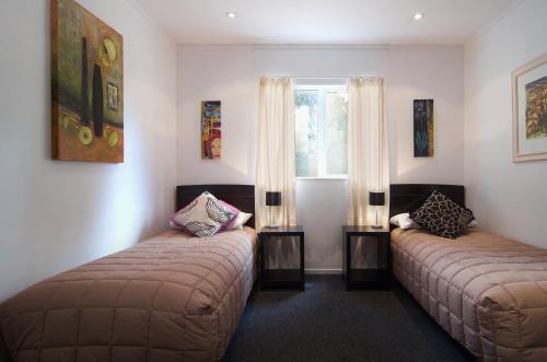 um quarto com duas camas e uma janela em Nut Point Cottage em West Melton