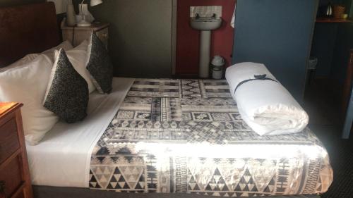 a bedroom with a bed with white sheets and pillows at A Stone's Throw Accommodation in Grahamstown