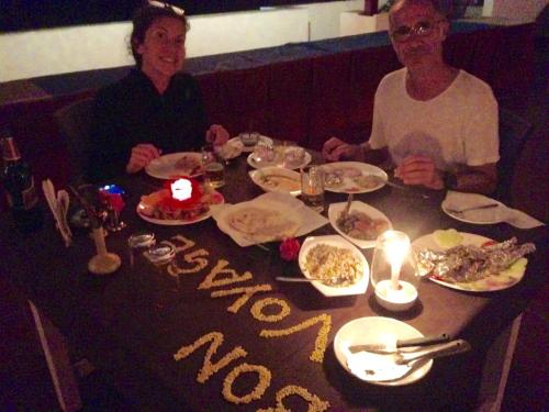 two people sitting at a table with plates of food at Meya Beach Walk Hotel in Mahabalipuram