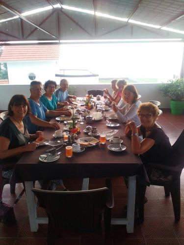 a group of people sitting around a long table at Meya Beach Walk Hotel in Mahabalipuram