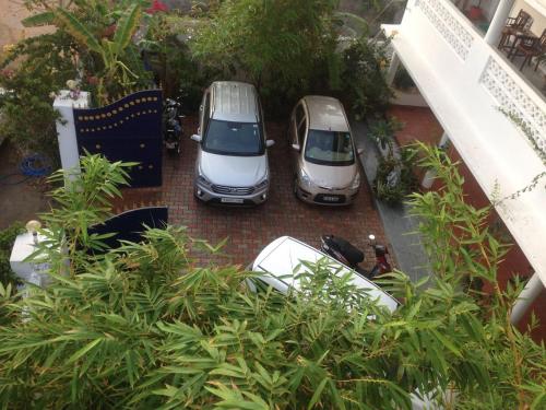 two white cars parked in a parking lot at Meya Beach Walk Hotel in Mahabalipuram