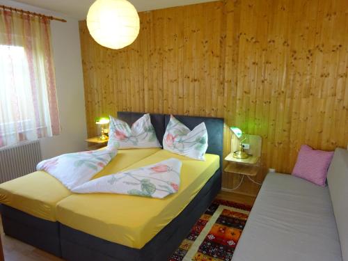 a bedroom with a bed with yellow sheets and pillows at FeWo Graz in Graz
