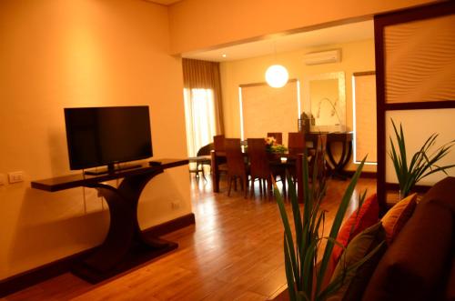 a living room with a flat screen tv on a table at Hotel Monticello Tagaytay in Tagaytay