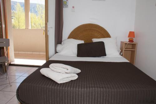 - une chambre avec un lit et 2 serviettes dans l'établissement Camping Les Prades, à Mostuéjouls