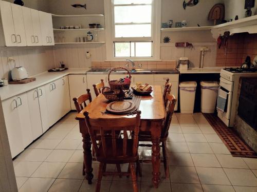 Metcalfe的住宿－金羅斯梅特卡夫農場別墅，厨房配有木桌和椅子