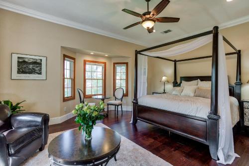 a bedroom with a canopy bed and a living room at Hope Inn Redding in Redding