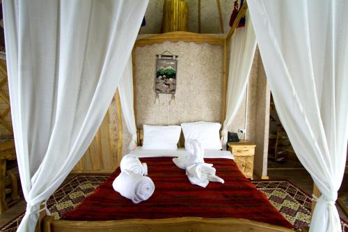 ein Schlafzimmer mit einem Bett mit Handtüchern darauf in der Unterkunft Supara Chunkurchak in Alamedin