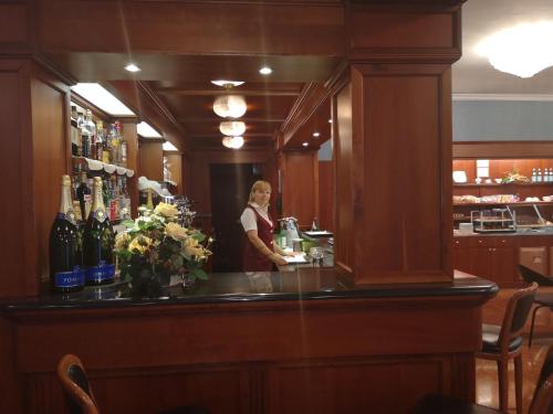 a woman standing behind a bar in a restaurant at Hotel Motel Luna in Segrate