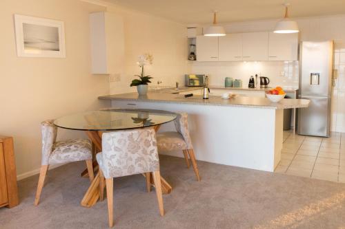 a kitchen with a table and chairs in a kitchen at Coral Island in Bloubergstrand