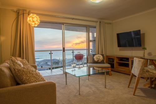a living room with a view of the ocean at Coral Island in Bloubergstrand
