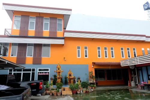 een oranje gebouw met water ervoor bij Banpong Center Place in Ban Khung Phayom