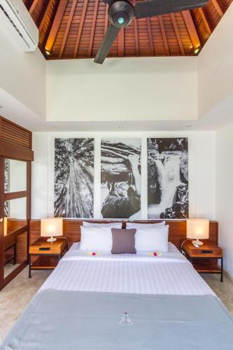 a bedroom with a large white bed with two tables at Vishuddha Ajna Villa - Outstanding 2 bdr villa - GREAT LOCATION! in Seminyak