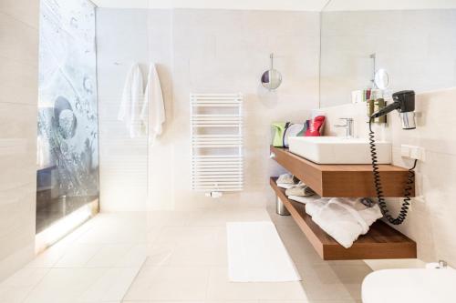 a bathroom with a sink and a shower at Thermenhotel Karawankenhof in Villach