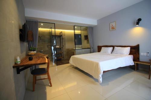 a bedroom with a bed and a desk and a bathroom at BK Hotel in Phnom Penh