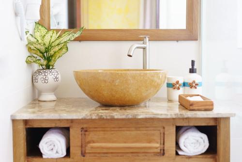 a bathroom counter with a bowl sink and a mirror at La Marina Boutique Hotel & Spa in Mui Ne