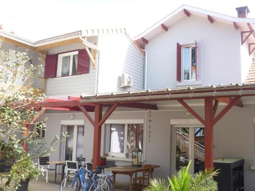 a house with a deck with bikes parked outside at Chez Augustin in Lacanau-Océan