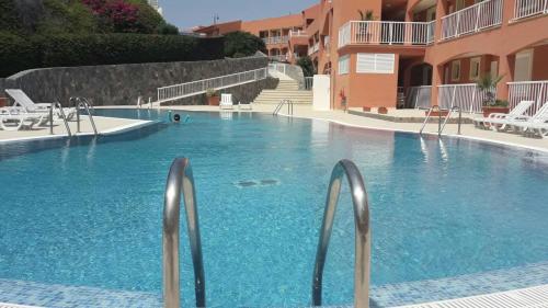 a swimming pool with blue water in a resort at Apart. Playa La Barca in Costa Calma
