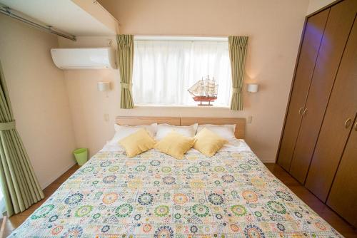 sypialnia z dużym łóżkiem i oknem w obiekcie Zushi Beach House w mieście Zushi