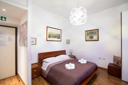 ein Schlafzimmer mit einem Bett mit zwei weißen Handtüchern darauf in der Unterkunft Parvula Domus al Colosseo in Rom