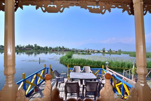a table and chairs on a boat in the water at Golden Hopes Group of Houseboats in Srinagar