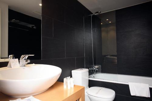 a bathroom with a sink and a toilet and a tub at Tierra de Biescas in Biescas