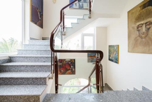 a staircase in a house with art on the walls at La Marina Boutique Hotel & Spa in Mui Ne
