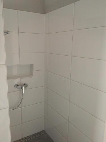 a bathroom with a shower with white tiles at Ferienhaus Pfaffensee in Harthausen