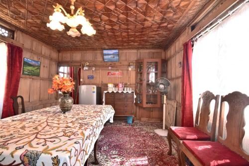 a dining room with a table and a refrigerator at Golden Hopes Group of Houseboats in Srinagar