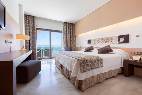 a hotel room with a bed and a large window at Hipotels Gran Conil in Conil de la Frontera