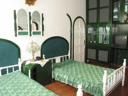 a bedroom with two beds and a table with a lamp at Pensiunea Ana Maria in Târgu-Mureş