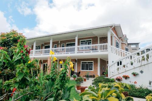 an exterior view of a house with plants at Kundasang Guesthouse in Kampong Kundassan