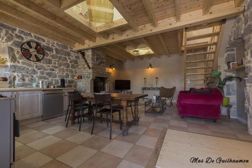 une cuisine et une salle à manger avec une table et des chaises dans l'établissement Mas de Guilhaumon côté hameau, à Joyeuse