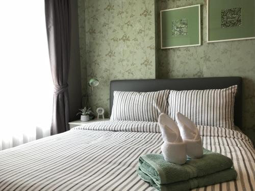 a bedroom with a bed with white shoes on a towel at Baan Kiang Fah By Greenday in Hua Hin