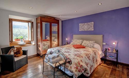 um quarto com uma cama e uma parede roxa em Casa Rural Artola Etxea em Baráibar