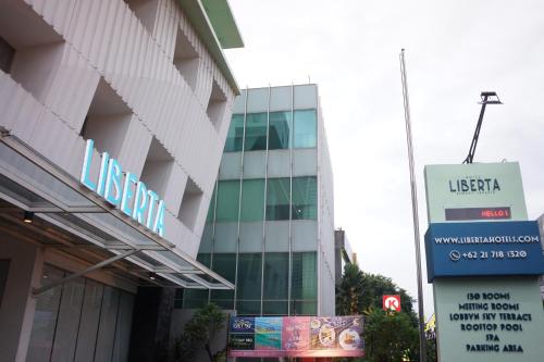 a building with a sign in front of it at Liberta Hotel Kemang in Jakarta