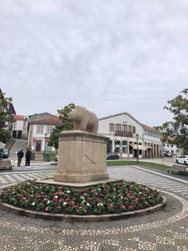 eine Statue in der Mitte eines Platzes mit Blumen in der Unterkunft Casa da Joana! in Murça