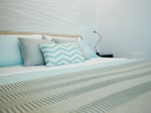 a bed with blue and white pillows on it at Verdeacqua in Monterosso al Mare