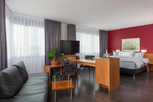 a hotel room with a bed and a desk at Hotel Wolfsburg Centrum, Affiliated by Meliá in Wolfsburg
