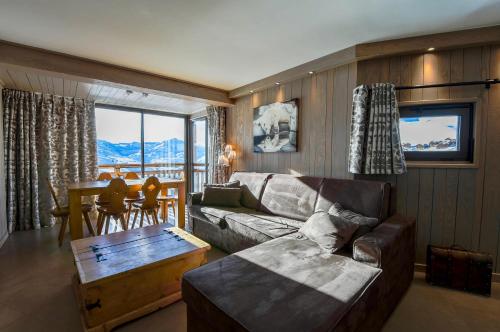 uma sala de estar com um sofá e uma mesa em A21 Roc de Péclet em Val Thorens