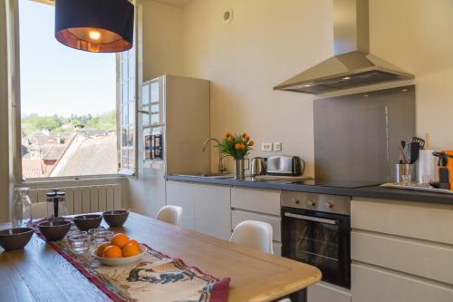 - une cuisine avec une table et des oranges dans l'établissement Le Grand Appartement d'Albusse, à Sarlat-la-Canéda