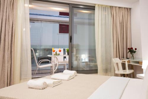 ein Schlafzimmer mit einem Bett, einem Tisch und einem Stuhl in der Unterkunft Elmaya's Duplex in Kissamos