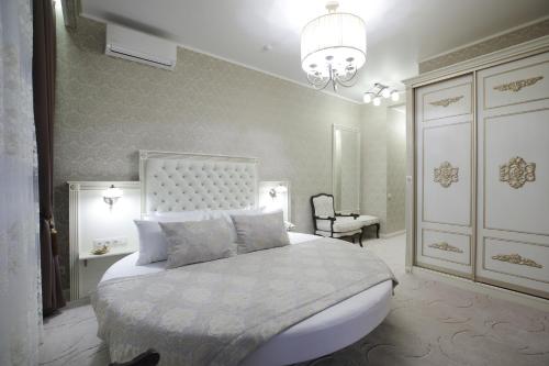 a bedroom with a large bed and a chandelier at Old Town in Tomsk