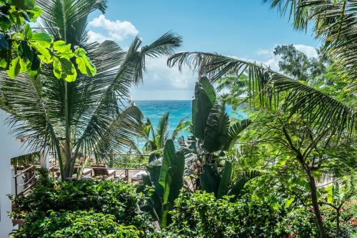 a view of the ocean from a resort with palm trees at Baia Sonambula in Praia do Tofo