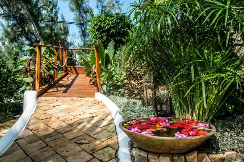 a garden with a bowl of flowers on a walkway at Baia Sonambula in Praia do Tofo