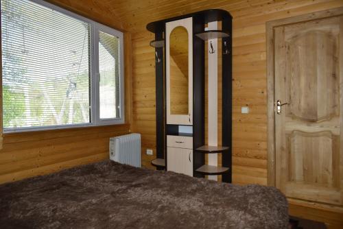 - une chambre avec un lit dans une pièce en bois dans l'établissement Хатина в Карпатах, à Verkhovyna