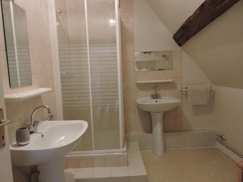 a white bathroom with a sink and a shower at Les Berges in Mareuil-sur-Cher